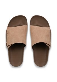 Tan suède diasandalen met een brede band, een geribbelde bruine rubberen zool en minimale branding aan de zijkant van de band. Klassiek, ingetogen ontwerp.