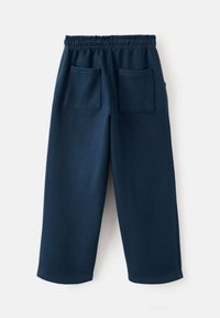 Námořnické modré tepláky s elastickým pasem, dvěma zadními kapsami a volným střihem. Vyrobené z jemné, texturované tkaniny se jednoduchým designem.