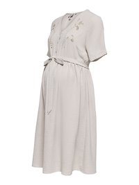 Robe de maternité beige clair avec manches courtes, col en V, broderie florale sur la poitrine et ceinture nouée à la taille.