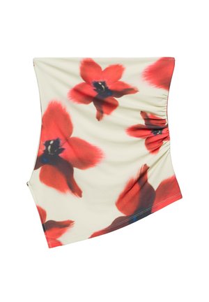 Jupe asymétrique couleur crème avec grand imprimé floral rouge et noir et détail froncé sur le côté.