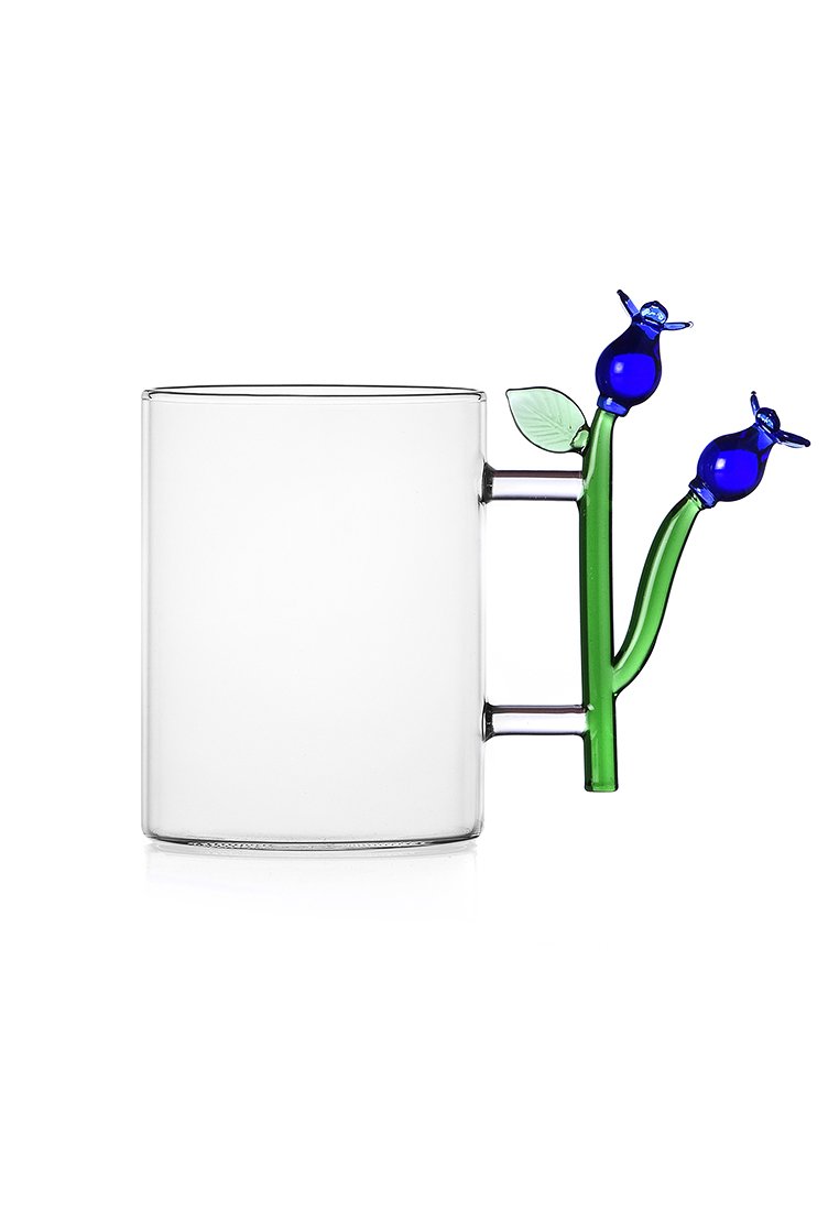 Duidelijke glazen mok met een handvat in de vorm van groene stelen, twee blauwe bloemknoppen en een klein groen blad.