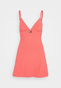 Vestido de color coral con canalé, escote en V y tirantes finos. Presenta un corsé ajustado y una falda acampanada, acentuado por una pequeña etiqueta con el logo en el centro.