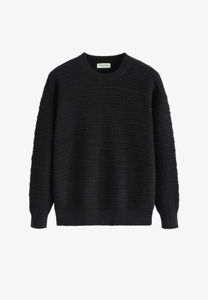 Pull noir en tricot texturé, présentant des rayures horizontales et des poignets côtelés. Design à col ras du cou, légèrement ample.