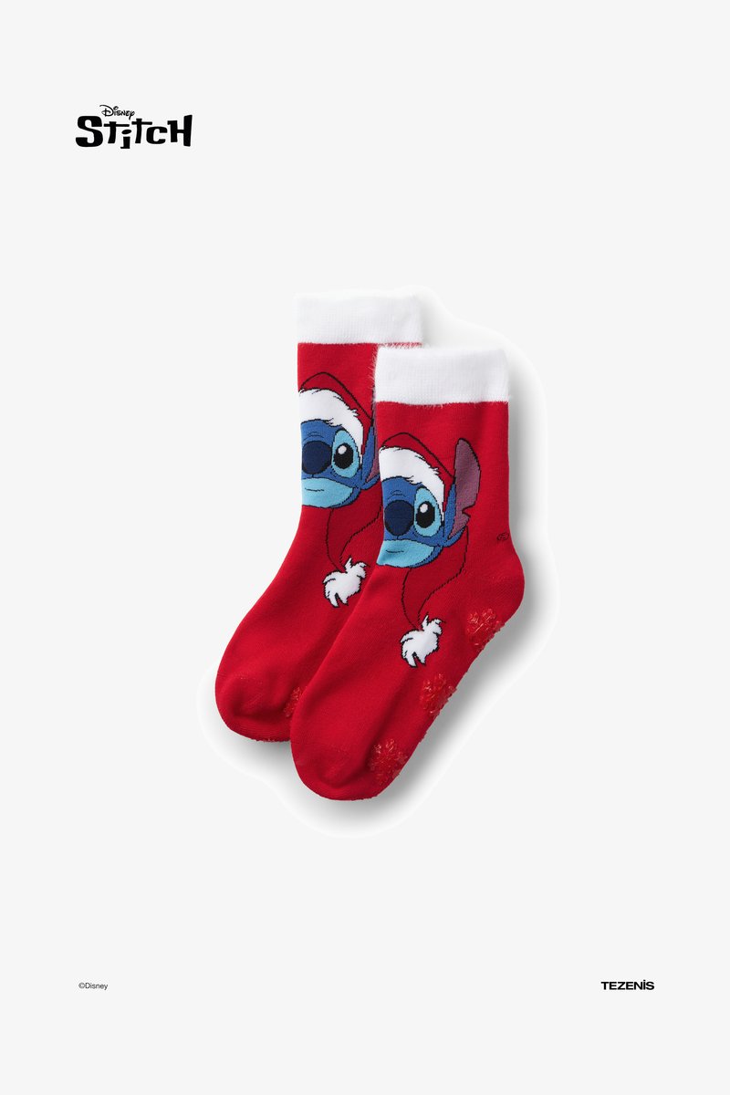 Chaussettes rouges ornées d'un personnage de dessin animé avec un visage bleu et un bonnet de Père Noël blanc, des poignets blancs et des motifs de flocons de neige en bas.