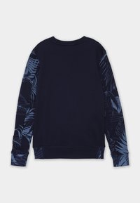 Maglione a maniche lunghe blu navy con motivi di foglie tropicali blu su entrambe le maniche, polsini a coste e colletto rotondo, mostrato da dietro.
