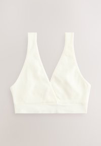 Hvid ribbet bralette med V-udskæring, brede skulderstropper og en blød elastik forneden. Jævn tekstur over det hele.