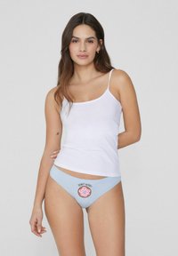 Helle blaue Unterwäsche mit dem Slogan "DONUT WORRY" und einem Donut-Graphic auf der Vorderseite, getragen mit einem körpernahen weißen Tanktop. Feines Material, elastischer Sitz.