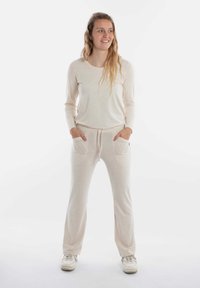 Lichtbeige tweedelige loungewearset met lange mouwen en zijkanten zakken. Zacht, gemêleerd stof met een ontspannen pasvorm en een verstelbare tailleband.