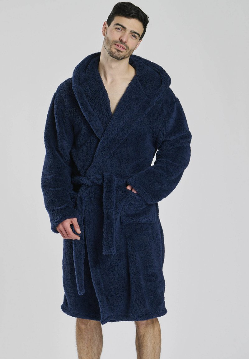 Navyblauer Bademantel aus plüschigem Stoff, mit Kapuze, Bindegürtel und Seitentaschen; knielang mit weicher, strukturiertem Aussehen.