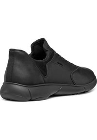 Sneaker in pelle nera con un design a profilo basso, dettagli in tessuto testurizzato e suola ammortizzata. Presenta uno stile slip-on e dettagli minimi.