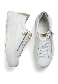 Sneakers bianchi in pelle con una suola bianca testurizzata, caratterizzate da un accento metallico oro sul tallone e una cerniera decorativa laterale.