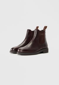 Dark brown leather ankle boots with elastic side panels and pull tabs, low heel, and "GANT" branding on the side panel.