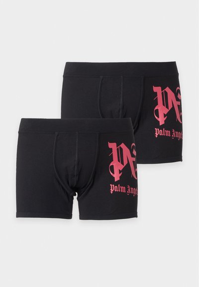 Deux boxers noirs avec un texte rose de style gothique "Palm Angels" imprimé sur la jambe gauche, présentés sur un fond clair.