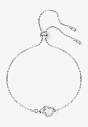Ezüst, állítható karkötő, amelyben végtelen szimbólum egy szívvel összefonódik, és a szív formát kis átlátszó drágakövek díszítik.
