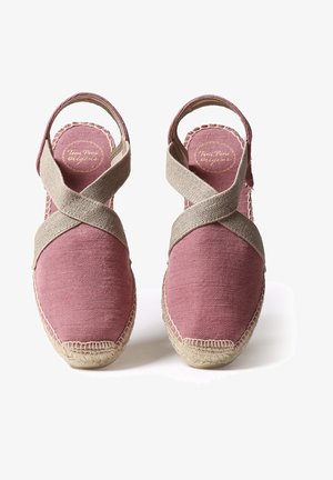 Rožinės espadrilės su kryžminėmis smėlio spalvos drobės juostelėmis. Natūralaus jūto virvės padas su siuvinėjimu. Atviras kulno dizainas.