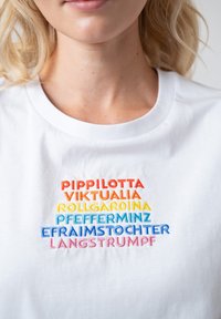 Weißes Baumwoll-T-Shirt mit mehrfarbigem gesticktem Text in verschiedenen Schriftarten: Rot, Orange, Gelb, Blau und Pink in einem gestapelten Layout.