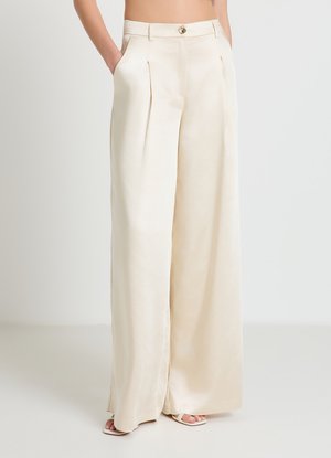 Pantalon crème à jambes larges avec une texture satinée lisse, doté de plis à l'avant et d'un bouton doré à la taille. Comprend des poches latérales.