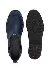 Zapatos de tipo slip-on en azul marino, con un diseño de parte superior sintética lisa y un interior forrado de fieltro. Suela de goma negra con tracción y detalles moteados en rojo.