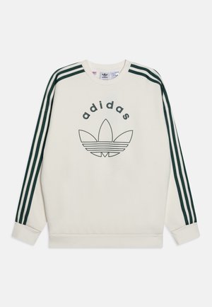 Sweat-shirt crème Adidas avec trois bandes vert foncé sur les manches et grand logo trèfle Adidas à l'avant.