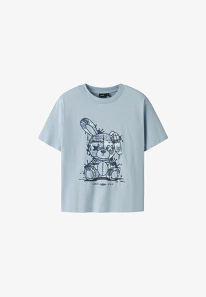 Camiseta de algodón azul claro con un gráfico de un conejo de dibujos animados con un diseño estampado y efectos de salpicaduras. Mangas cortas, escote redondo.