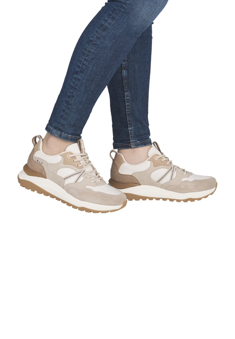 Des chaussures de sport beiges et blanches en matériaux suédés et en maille, avec une épaisse semelle en caoutchouc beige et un design à lacets, sur fond blanc.