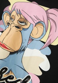 Camiseta gráfica con un mono de dibujos animados con pelo rosa, piel azul y un fondo negro. Incluye texto con lentejuelas en la parte inferior.