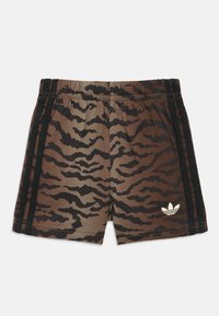 Pantalones cortos con estampado de rayas de tigre marrón y negro, con cintura elástica, franjas laterales negras y el logotipo blanco de trébol de Adidas en la pierna derecha.