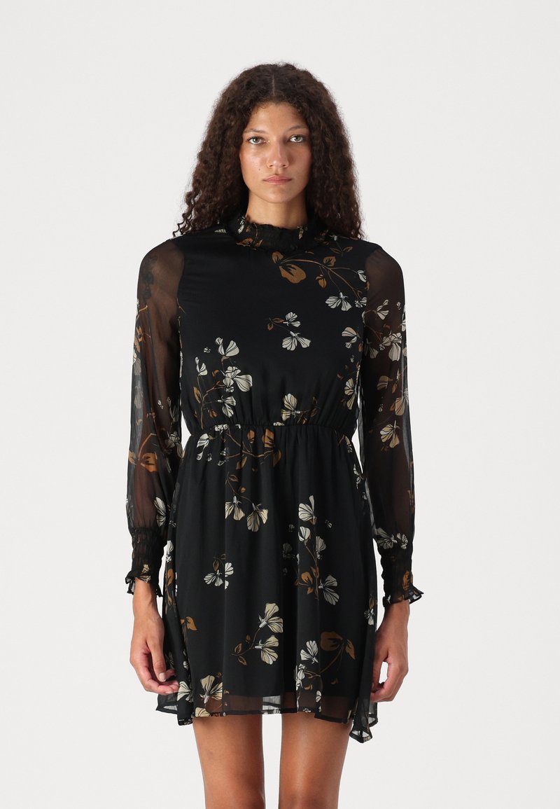 Rochie neagră cu flori, cu mâneci lungi din material transparent, decolteu volanat, talie elastică și croi lejer cu tiv fluid.