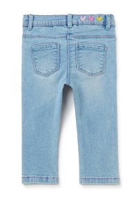 Jeans de mezclilla azul claro con un corte slim, que cuentan con dos bolsillos traseros y corazones bordados en rosa, morado y amarillo en la cinturilla.