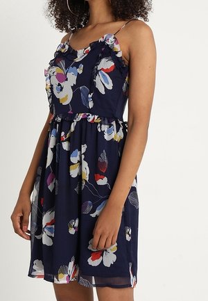 Mørkeblå blomsterkjole med flæsekrave og stropper, med flerfarvet blomsterprint, tætsiddende talje og en svævende nederdel.