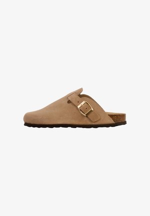 Sabot beige en daim à enfiler avec bride réglable à boucle dorée, semelle intérieure en liège et semelle extérieure noire texturée.