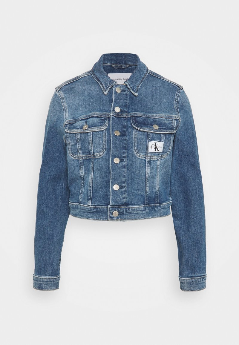 Giacca di jeans blu chiaro a cropped con maniche lunghe, chiusura con bottoni, due tasche sul petto e una piccola etichetta con logo sulla tasca sinistra.