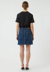 Denim A-linjainen hame tummansinisessä värissä, viisi taskua ja vaaleanruskea nahkaleima takana vyötäröllä. Yhdistetty mustaan t-paitaan.