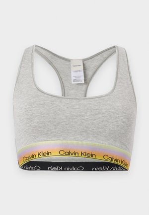 Világosszürke racerback sportmelltartó, Calvin Klein márkájú elasztikus pántokkal, amelyek szivárvány és fekete színárnyalatokban vannak.
