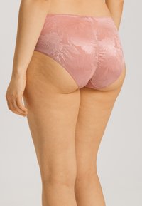 Rosa spetsunderkläder med blomsterdesign, högskuren modell, slät textur och sömlös finish för komfort och stil.
