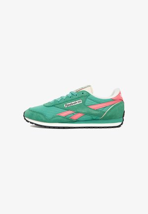 Zapatilla deportiva verde y rosa con parte superior de ante y malla, diseño texturizado, suela de goma negra y marca Reebok en el lateral y la lengüeta.