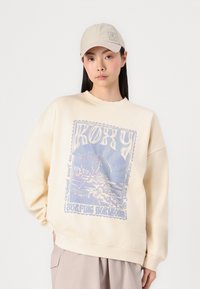 Kremfarget hettegenser med grafisk trykk som viser palmer og havbølger. Designet har en avslappet passform og ribbestrikkede mansjetter. Beige caps.