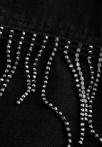 Juodas denimo audinys turi dekoratyvinius pūkelius iš kvadratinių ir apvalių juodų blizgučių. Tekstūra yra lygi su matinėmis apdailos.