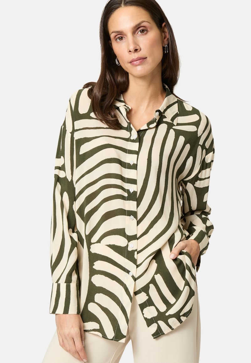 Green and beige button-up shirt featuring bold, curvy patterns, long sleeves, and a collar. Made from a lightweight, textured fabric.