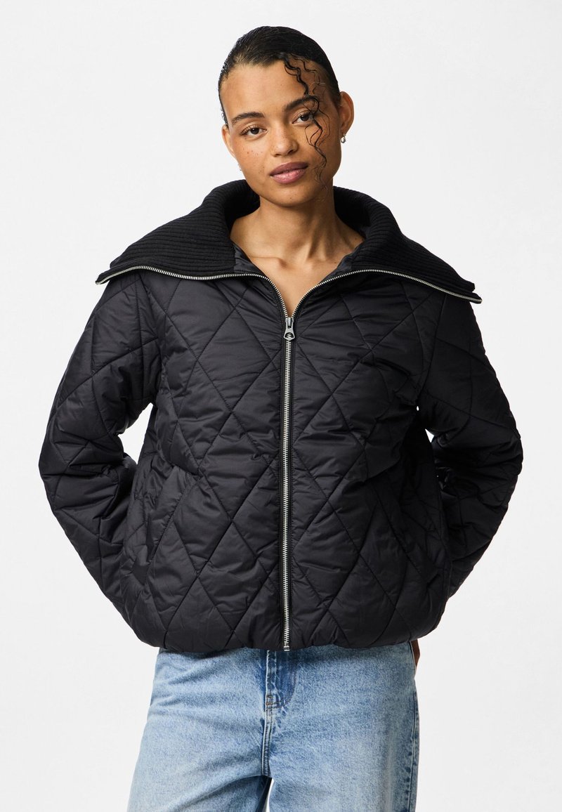 Kvaliteetne must õhkõrn jakk, millel on soonikkoes krae ja lukuga sulgu. Tekstureeritud kangas esitleb teemantmustreid. Kantud helesiniste teksadega.