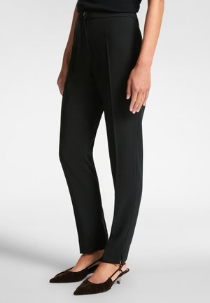 Pantaloni sartoriali neri con design a gamba dritta, caratterizzati da chiusura frontale con bottoni e spacchi alla caviglia. Tessuto dalla texture liscia.