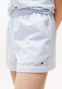 Lichtblauwe en witte gestreepte shorts gemaakt van zachte stof, met een elastische tailleband en een logo-accent op de zoom.