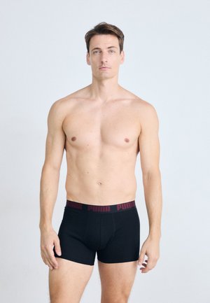 Boxeri negri cu talie elastică roșie, având logo-ul "PUMA". Design neted și ajustat, cu cusături minime pentru confort și suport.