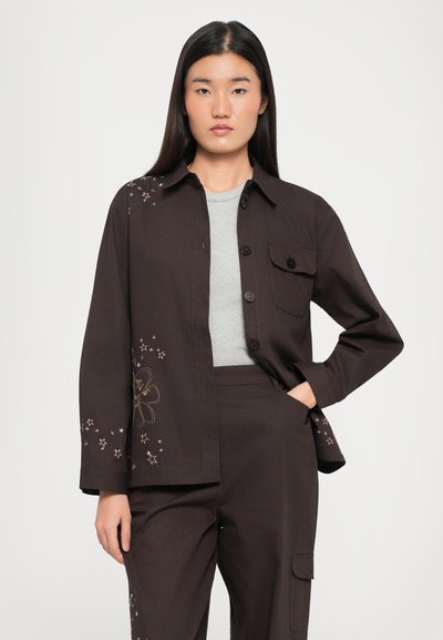 Brown jacket with long sleeves, front buttons, and left pocket; features floral and star embroidery in gold and pastel colors.