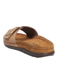 Bruna mockasiner i suède med en bred ovandel och en gyllene spänne som accent. Texturerad innersula, platt sula och sydda detaljer längs kanterna.