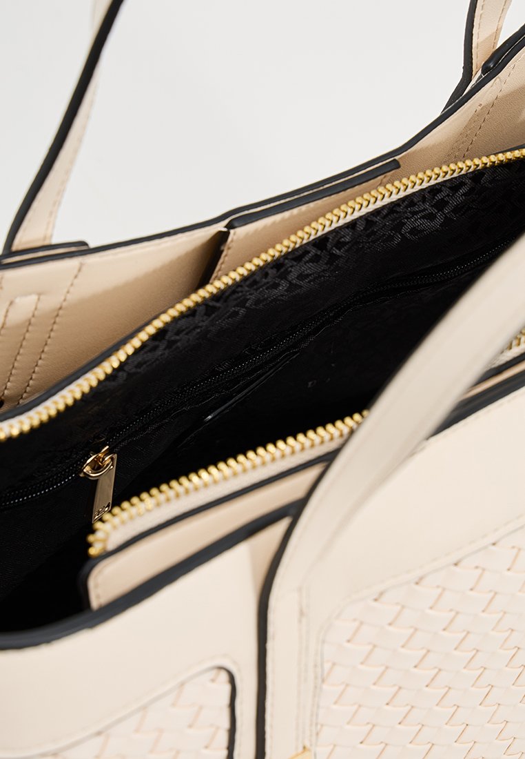 Beige schoudertas met geweven textuur en zwarte accenten. Gouden rits en ritszak zichtbaar aan de binnenkant. Glad binnenfutter.