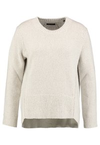 Maglione lavorato a maglia color beige chiaro con collo rotondo, maniche lunghe, orlo a coste e spacchi laterali. Il tessuto texturizzato offre un aspetto accogliente.