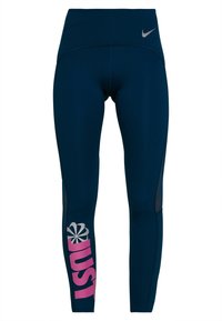 Laadukkaat tummansiniset leggingsit, joissa on korkea vyötärö, hopeinen Nike-logo ja suuri vaaleanpunainen "JUST" -teksti vasemmassa lahkeessa. Verkkokankaita säären lähellä.