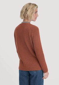 Rippstrick-Pullover in rostrot mit Rundhalsausschnitt und grauen Akzenten; an den Schultern tailliert und am Saum locker; strukturierter Strickstoff.