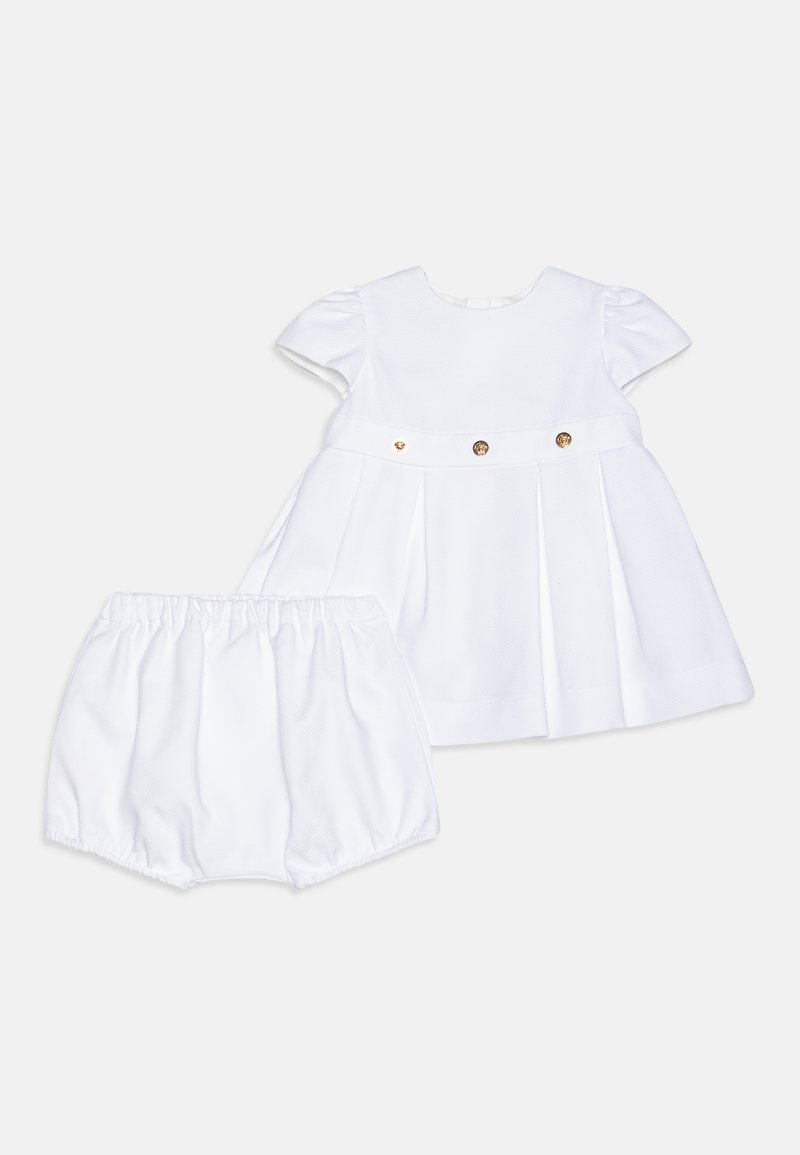 Hvit bomulls kjole med korte puffermer, folder og gullknappefester; inkluderer matchende hvite bloomer-shorts med elastisk midjebånd.